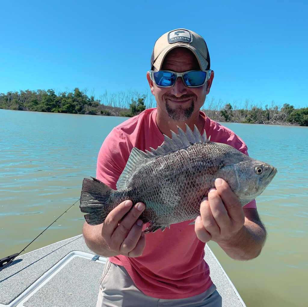 Man aboard boat holds up a huge fish