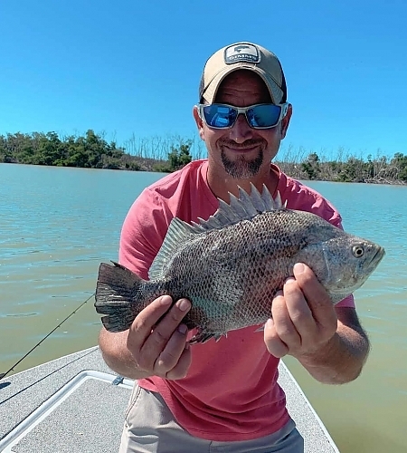 Man aboard boat holds up a huge fish